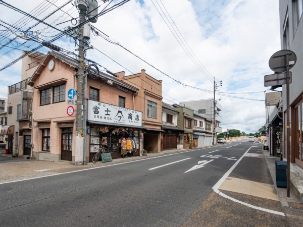 取材時に見学した客室。左上：ベッド。右上：藍染めのカーテン。ほどよい色落ち具合になっている。左下：テーブル・椅子は特注品。右下：岡山が誇る伝統工芸・備前焼でできた洗面ボウル