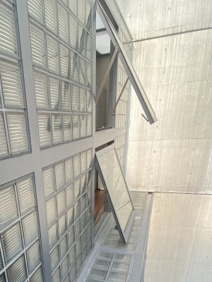 2階の開閉窓から顔を出して別の開閉窓を見る。ガラスブロックの水平部分の先端に雨水の排水経路があるのがわかる（写真：宮沢洋）