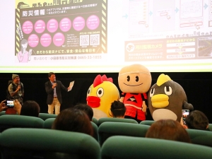 TOHOシネマズ小田原で行われたイベントで登壇し、小田原市の防災への取り組みや「おだわら防災ナビ」の紹介を行った加藤憲一・小田原市長。小田原市も後援となり、官民一体となって防災対策に取り組んでいる。そらジローとくもジローの間にいるのが小田原市のキャラクターの「梅丸」
