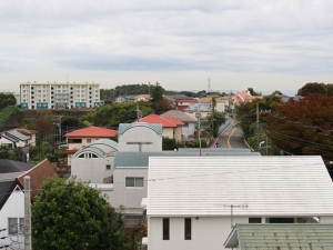 住棟によっては山や海が見える。天気が悪かったせいで不鮮明だが、この部屋も遠くに海が見える（筆者撮影）