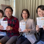 4名が同じ本の表紙を胸に掲げてソファーに座っている。