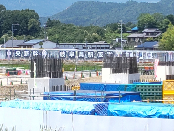 日々姿を変えるリニア岐阜県駅の工事現場。背後には田畑と里山、集落が広がるのどかな風景が対照的に広がる　